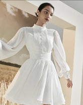 Mini silk dress with structured bodice, lantern sleeves, and flared pleated skirt
